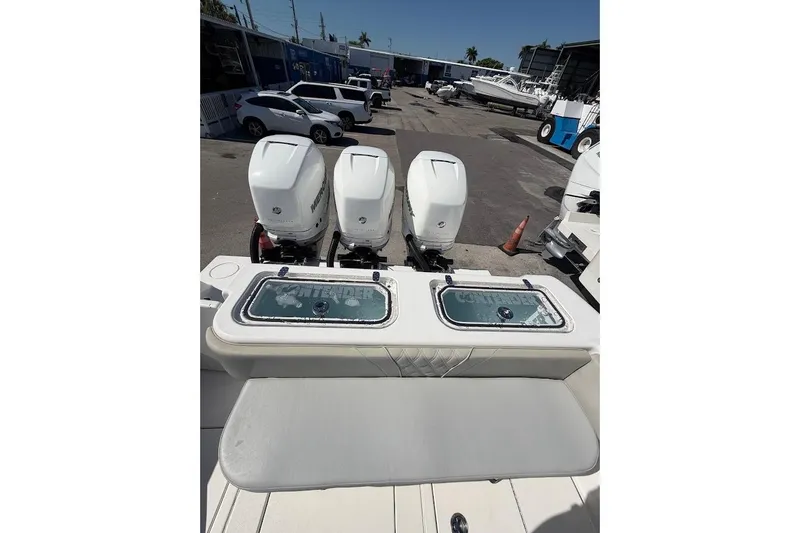 Slide: The Image of Triple outboard motors on a 2021 Contender boat, parked in a marina. - 16