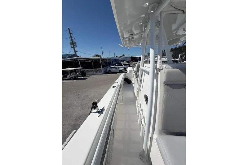 Slide: The Image of 2021 Contender boat interior with sleek white seating and modern design in a parking lot setting. - 20