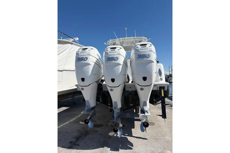 Slide: The Image of Triple Mercury Verado 350 outboard engines on a 2021 Contender boat under clear blue sky. - 5