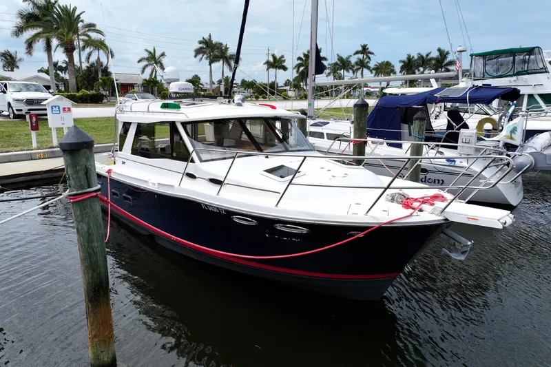The Image of 2015 Cutwater 30 Sedan docked at marina with palm trees in background. - 0
