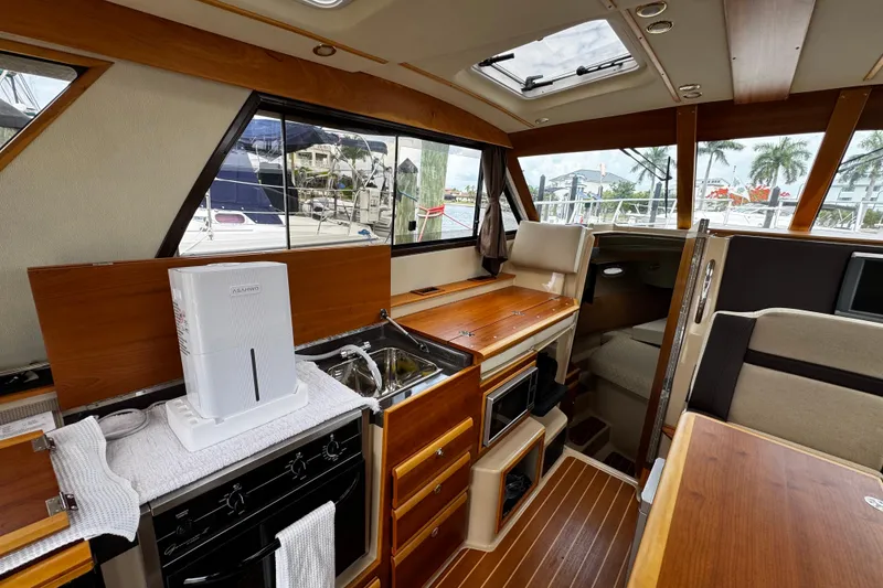 Slide: The Image of Interior of 2015 Cutwater 30 Sedan boat with kitchen and seating area. - 10