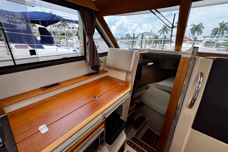 Slide: The Image of Interior of a 2015 Cutwater 30 Sedan boat with wooden table and seating area. - 12
