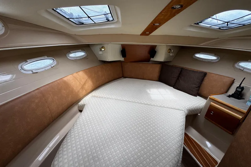 Slide: The Image of Interior cabin of a 2015 Cutwater 30 Sedan boat with cozy bedding and portholes. - 14
