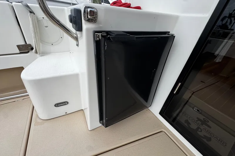 Slide: The Image of 2015 Cutwater 30 Sedan boat interior with a compact black refrigerator. - 19