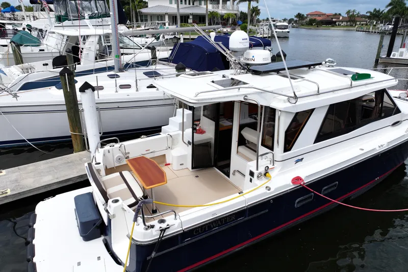 Slide: The Image of 2015 Cutwater 30 Sedan docked at a marina, featuring a spacious deck and modern design. - 2