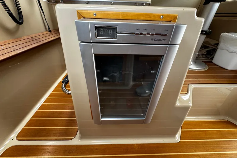 Slide: The Image of Dometic fridge in 2015 Cutwater 30 Sedan boat interior with wood flooring. - 21