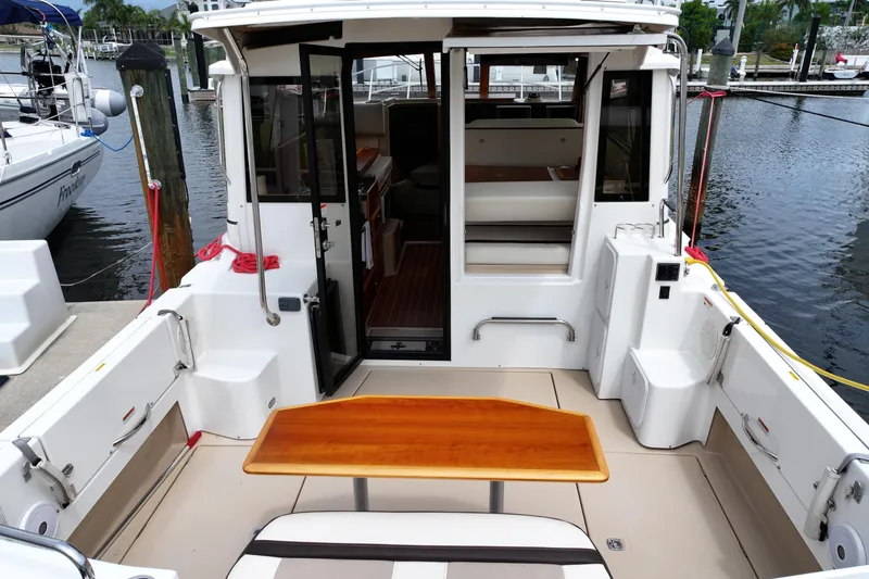 Slide: The Image of 2015 Cutwater 30 Sedan boat interior with wooden table, docked at marina. - 3