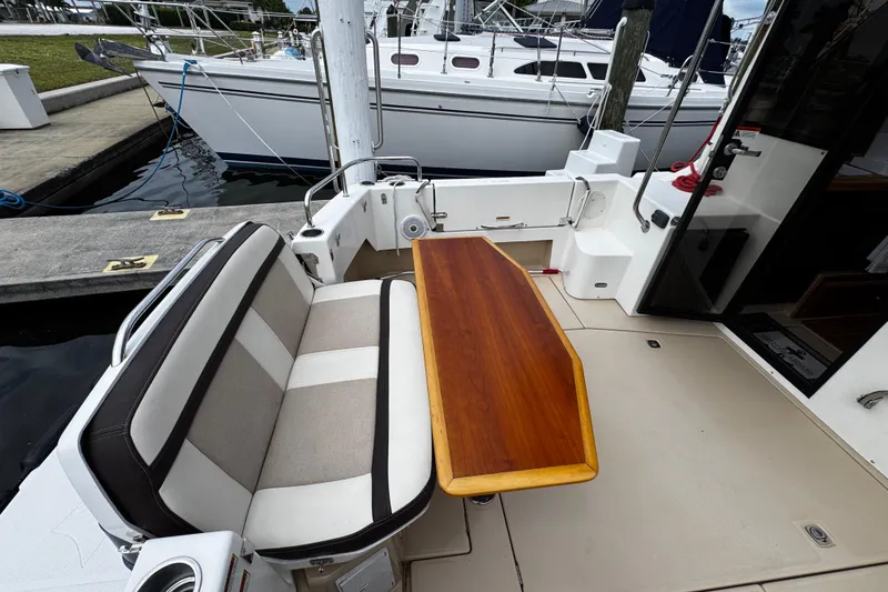 Slide: The Image of 2015 Cutwater 30 Sedan boat interior with cushioned seating and wooden table. - 4