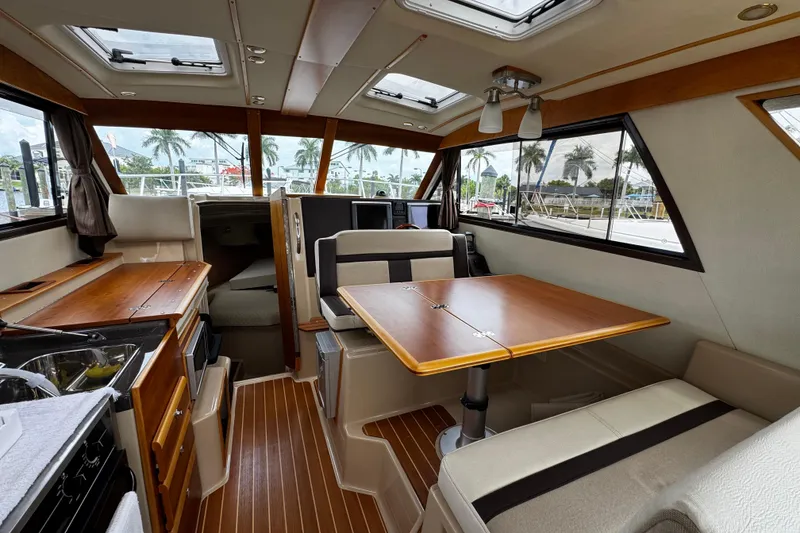 Slide: The Image of Interior of 2015 Cutwater 30 Sedan boat with wood accents and seating area. - 7