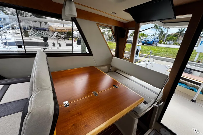 Slide: The Image of Interior of a 2015 Cutwater 30 Sedan boat with wooden table and seating. - 8