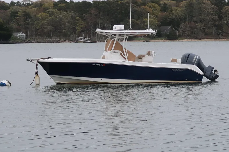 The Image of 2017 Edgewater 245CC boat anchored on calm water with scenic forest backdrop. - 1