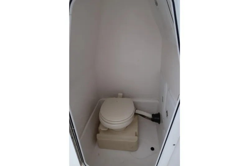 Slide: The Image of 2017 Edgewater 245CC boat interior with compact marine toilet. - 11