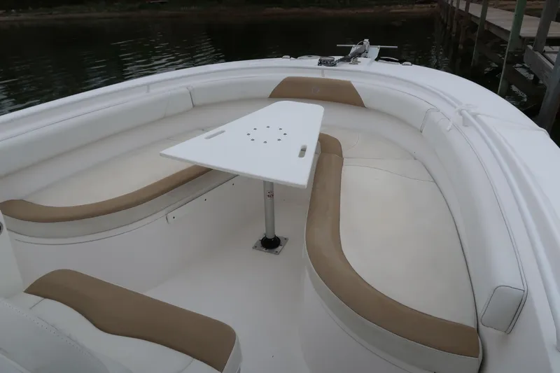 Slide: The Image of 2017 Edgewater 245CC boat interior with cushioned seating and a central table. - 14