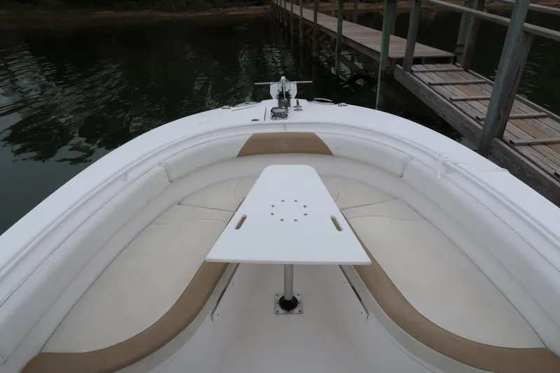 Slide: The Image of 2017 Edgewater 245CC boat interior with seating and table near dock. - 15