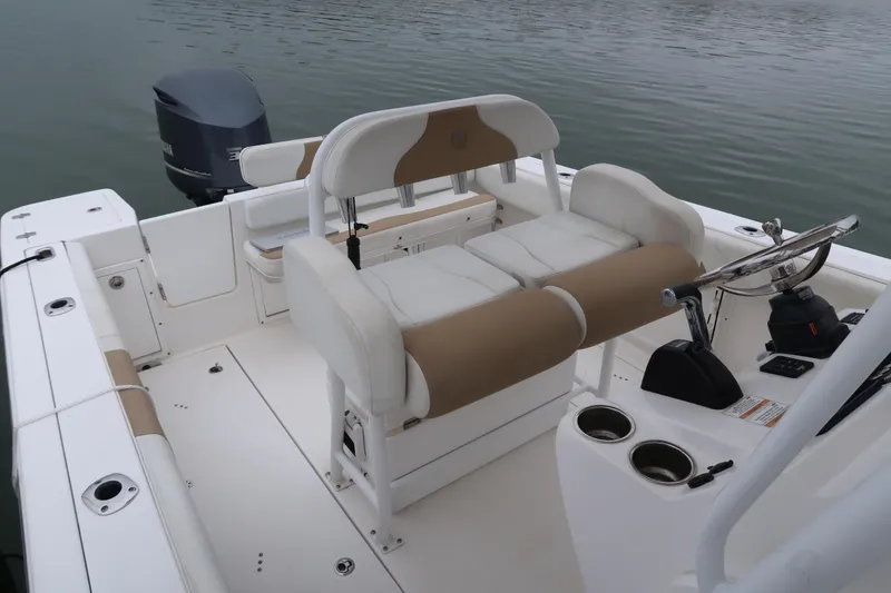 Slide: The Image of Edgewater 245CC 2017 boat interior with seating and steering wheel on calm water. - 7