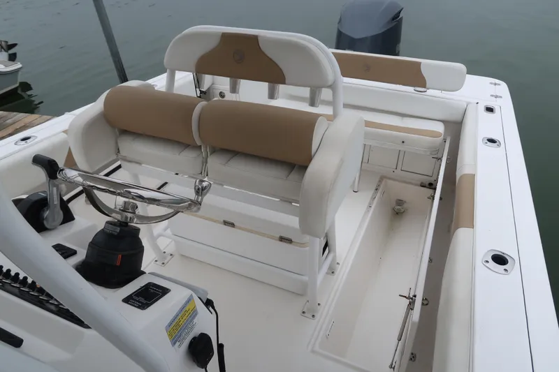 Slide: The Image of 2017 Edgewater 245CC boat interior with helm, seating, and storage compartments. - 8