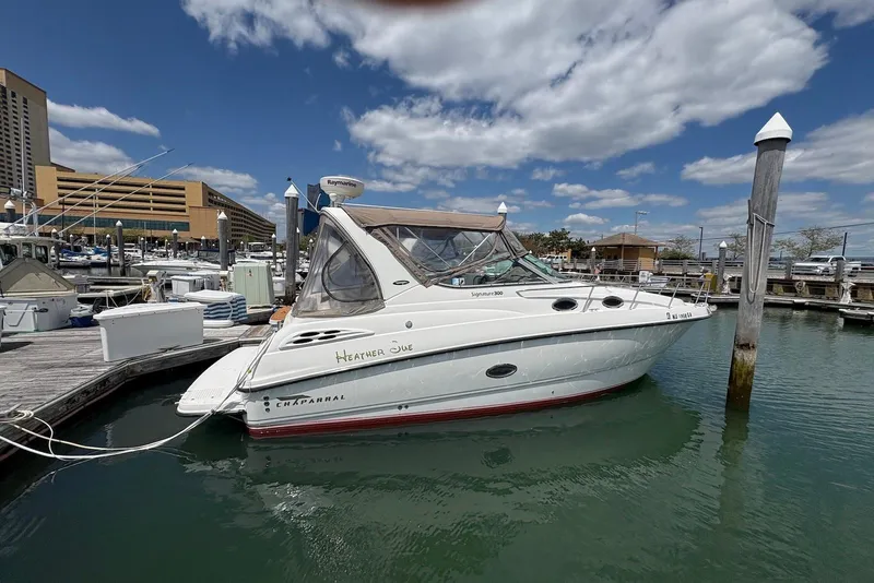 The Image of 1999 Chaparral Signature 300 boat docked at marina under blue sky. - 0