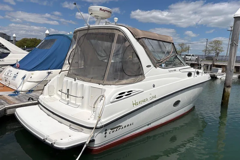 Slide: The Image of 1999 Chaparral Signature 300 boat docked at marina under clear skies. - 2