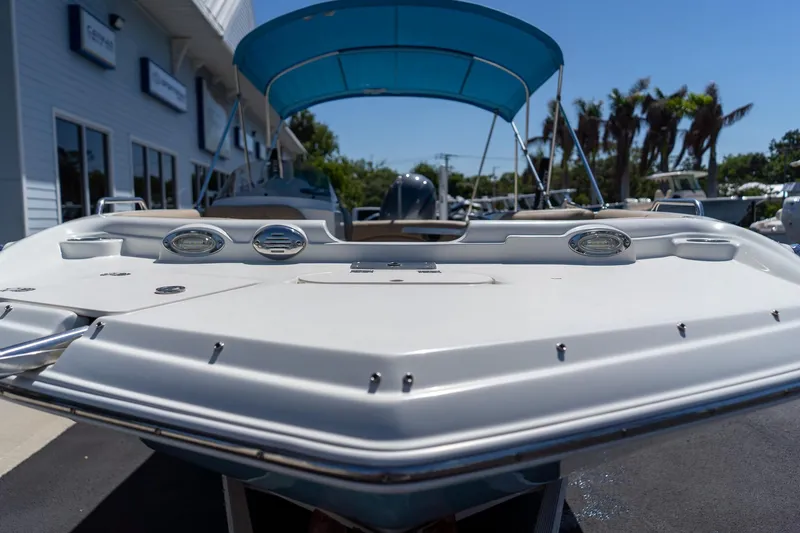 Slide: The Image of 2020 NauticStar 203 SC boat with blue canopy, docked near dealership. - 10