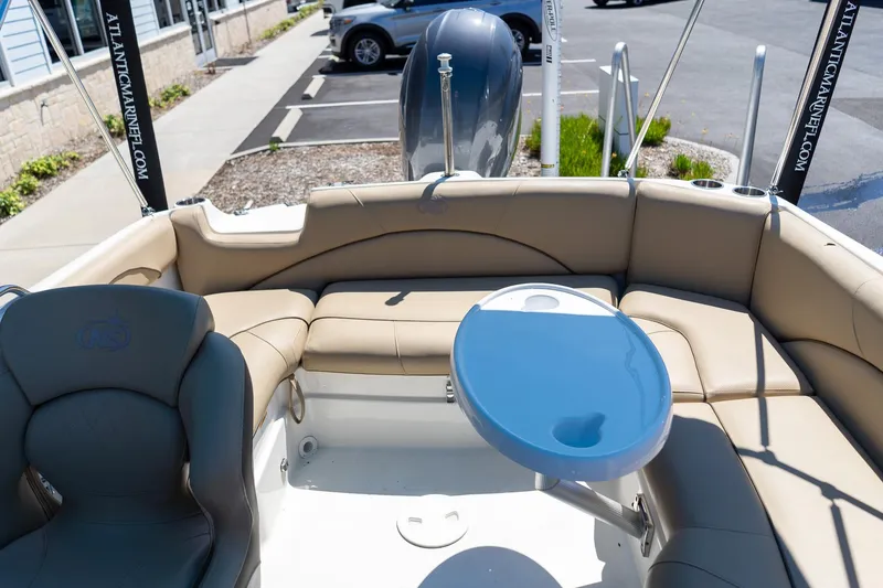 Slide: The Image of 2020 NauticStar 203 SC boat interior with tan seating and blue table. - 13