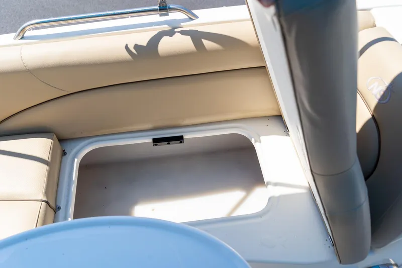 Slide: The Image of 2020 NauticStar 203 SC boat storage compartment with beige seating. - 15
