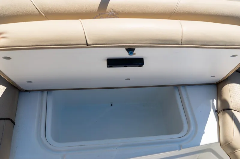 Slide: The Image of Storage compartment in a 2020 NauticStar 203 SC boat, featuring beige upholstery. - 16