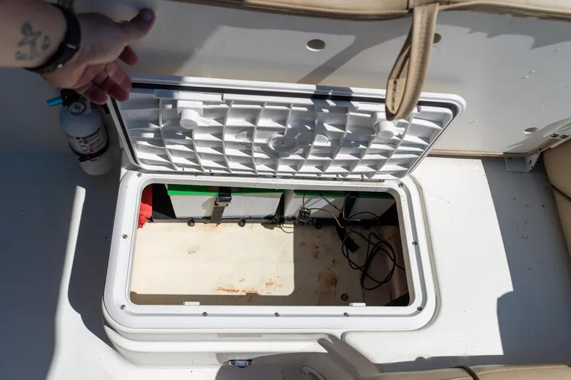 Slide: The Image of Open storage compartment on 2020 NauticStar 203 SC boat, showing interior and fire extinguisher. - 18