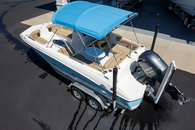 Slide: The Image of 2020 NauticStar 203 SC boat with blue canopy and Yamaha motor on trailer. - 2