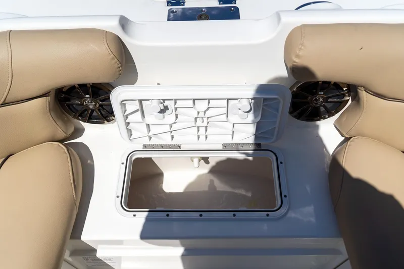 Slide: The Image of 2020 NauticStar 203 SC boat interior with open storage compartment and beige seating. - 28