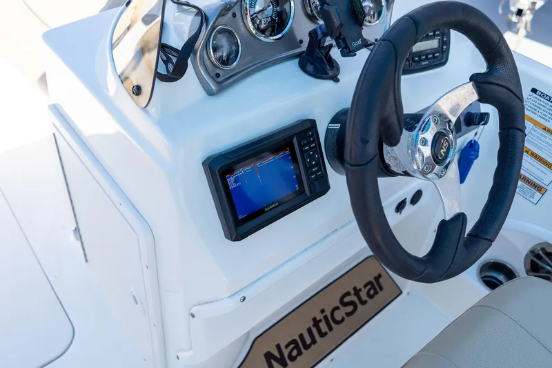 Slide: The Image of 2020 NauticStar 203 SC boat dashboard with steering wheel and navigation display. - 33