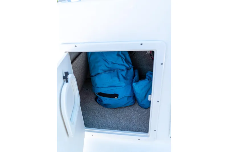 Slide: The Image of Storage compartment in 2020 NauticStar 203 SC boat with blue bags inside. - 35