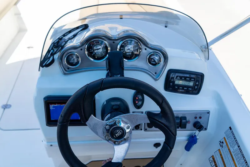 Slide: The Image of 2020 NauticStar 203 SC boat dashboard with steering wheel and gauges. - 36