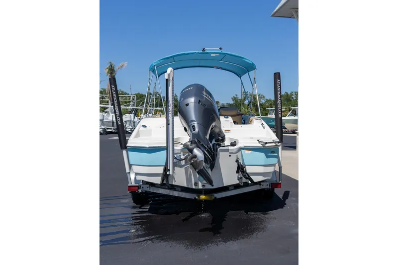 Slide: The Image of 2020 NauticStar 203 SC boat with outboard motor on trailer, blue canopy. - 7