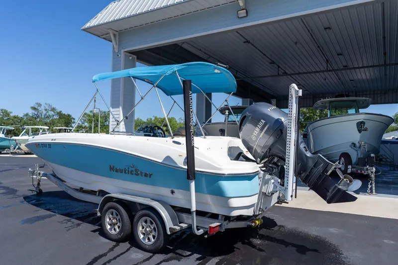 Slide: The Image of 2020 NauticStar 203 SC boat with Yamaha motor on trailer under canopy. - 8