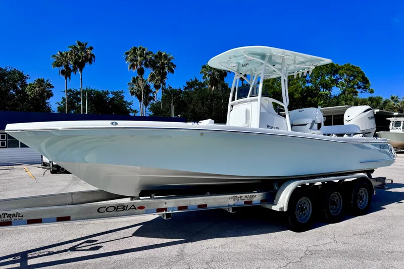 The Image of 2026 BlackJack 256 Coastal boat on trailer, parked outdoors under clear blue sky. - 0