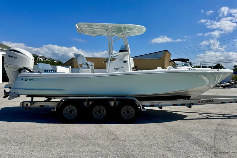 Slide: The Image of 2026 BlackJack 256 Coastal boat on trailer, featuring Yamaha engine, under clear blue sky. - 6