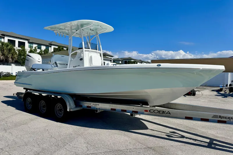 Slide: The Image of 2026 BlackJack 256 Coastal boat on trailer, parked outdoors under clear blue sky. - 7