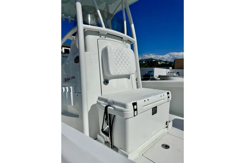 Slide: The Image of 2026 BlackJack 256 Coastal boat interior with seating and storage, under clear blue sky. - 9