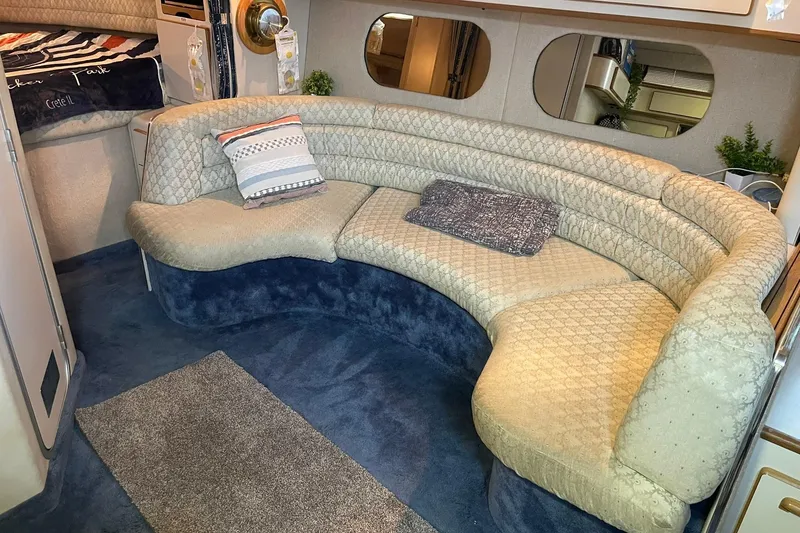 Slide: The Image of Interior of 1992 Sea Ray 370 Express Cruiser with curved seating and cozy decor. - 6
