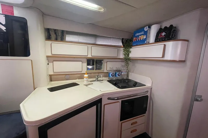 Slide: The Image of Interior view of 1992 Sea Ray 370 Express Cruiser kitchen area with stove and sink. - 9