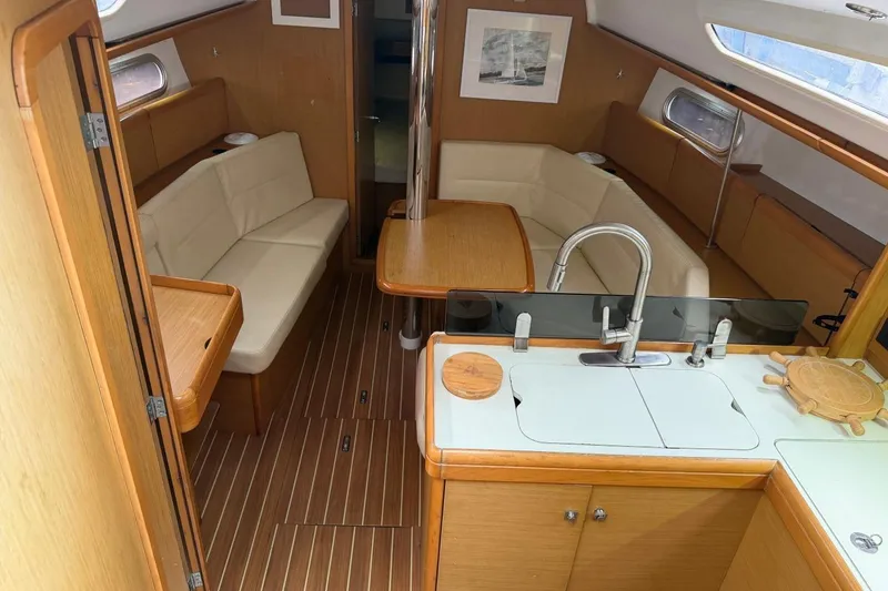 Slide: The Image of Interior of 2011 Jeanneau Sun Odyssey 36i sailboat with modern kitchen and cozy seating area. - 9