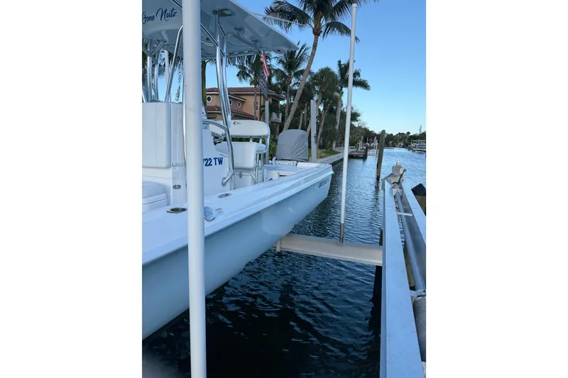 Slide: The Image of 2024 Contender 26 Bay boat docked by palm trees on a sunny day. - 3
