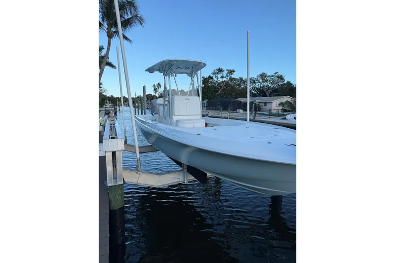Slide: The Image of 2024 Contender 26 Bay boat docked on a lift by the water. - 4