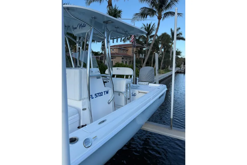 Slide: The Image of 2024 Contender 26 Bay boat docked by palm trees, featuring sleek design and modern amenities. - 8