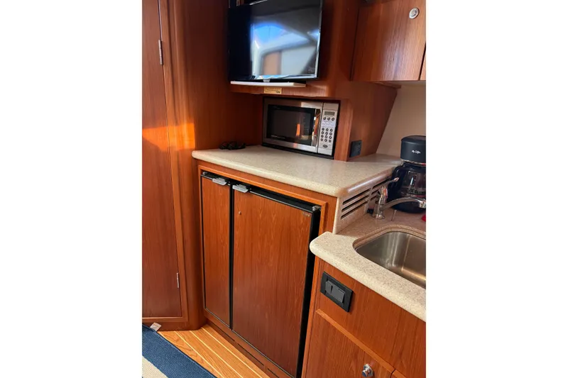 Slide: The Image of 2003 Tiara Yachts 3500 Open galley with microwave, fridge, and sink. - 10