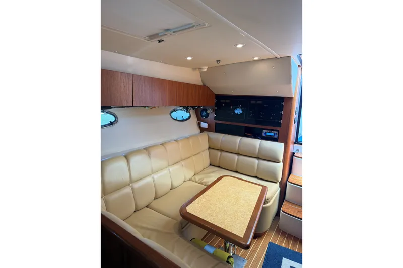 Slide: The Image of Interior of 2003 Tiara Yachts 3500 Open with beige seating and wooden accents. - 13