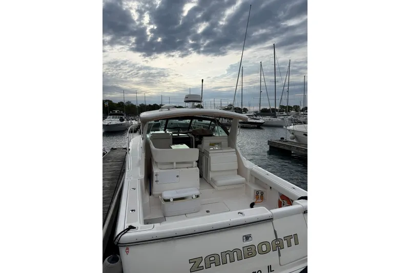 Slide: The Image of 2003 Tiara Yachts 3500 Open docked at marina under cloudy sky. - 2