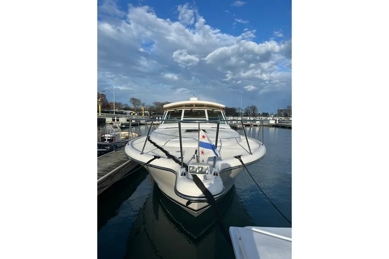 Slide: The Image of 2003 Tiara Yachts 3500 Open docked in a marina under a partly cloudy sky. - 4
