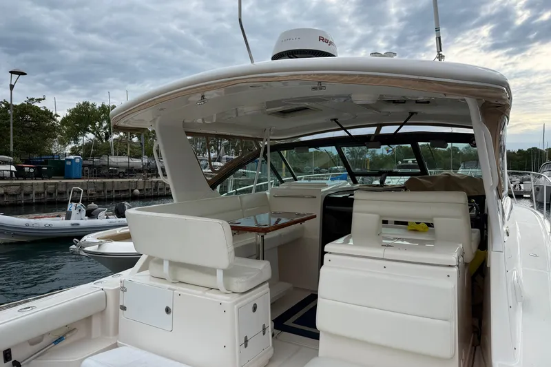 Slide: The Image of 2003 Tiara Yachts 3500 Open docked, showcasing spacious cockpit and seating area. - 6