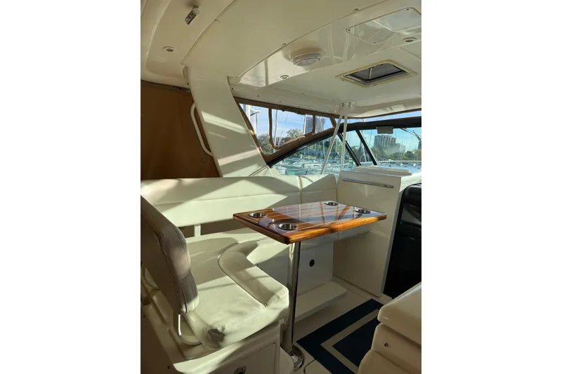 Slide: The Image of Interior of 2003 Tiara Yachts 3500 Open, featuring seating and a wooden table. - 7